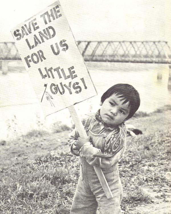 A small child holds up a sign saying