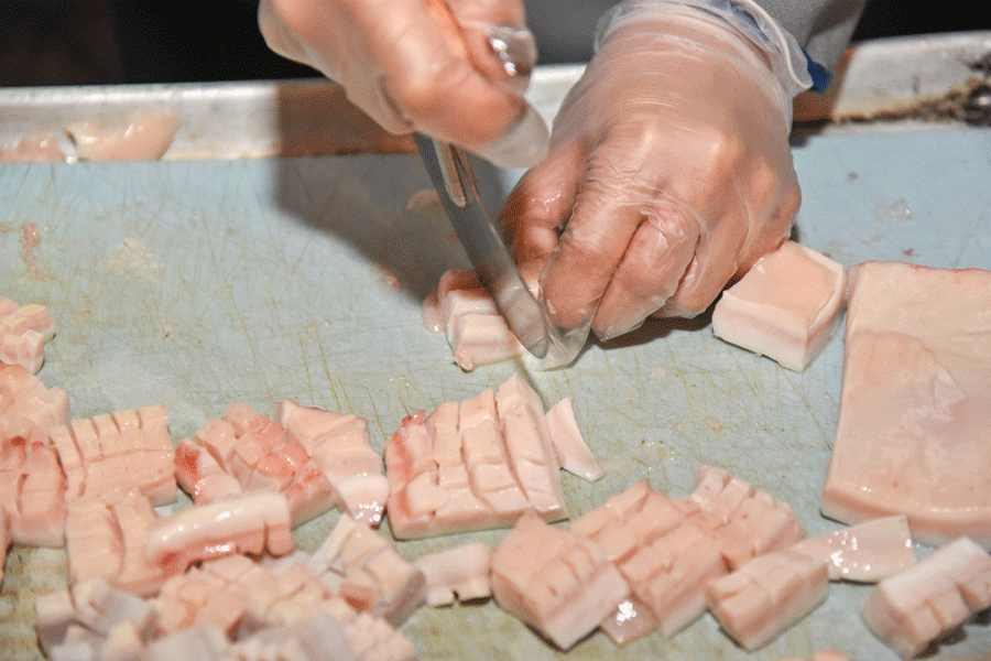 Cutting muktuk, frozen whale skin and blubber.
