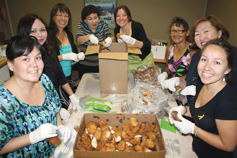 Inuit community preparing food for a community event.