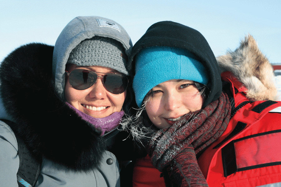 A close up of two women dressed in warm clothes smiling towards the camera