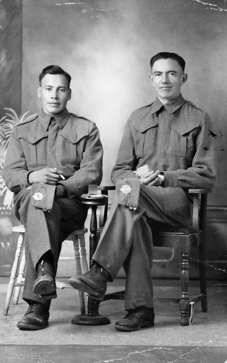 two men in uniform sitting on chairs